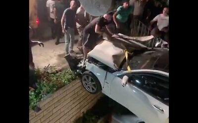 First responders lift a vehicle out of a yard in Ar'ara, northern Israel, July 30, 2020 (Kan screenshot)