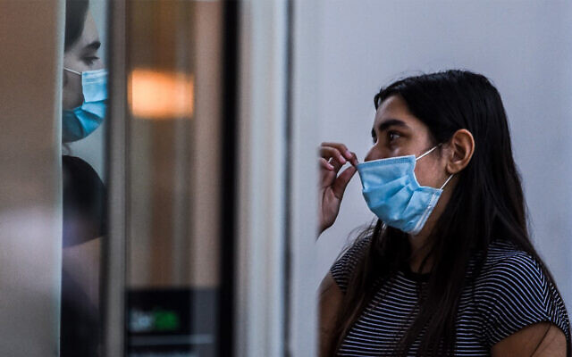 A woman wears a face mask as she talks to a friend at a shopping center in Miami Beach, Florida, June 29, 2020. (Chandan Khanna/AFP) A woman wears a face mask as she talks to a friend at a shopping center in Miami Beach, Florida, June 29, 2020. (Chandan Khanna/AFP)