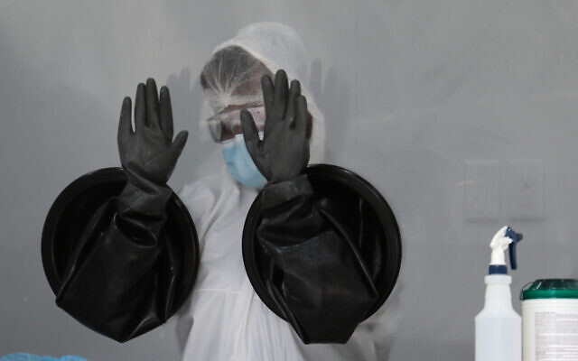 A health care worker air dries her gloves after sanitizing her equipment while working at a walk-up COVID-19 testing site in Miami Beach, Florida, July 17, 2020. (AP Photo/Lynne Sladky) A health care worker air dries her gloves after sanitizing her equipment while working at a walk-up COVID-19 testing site in Miami Beach, Florida, July 17, 2020. (AP Photo/Lynne Sladky)