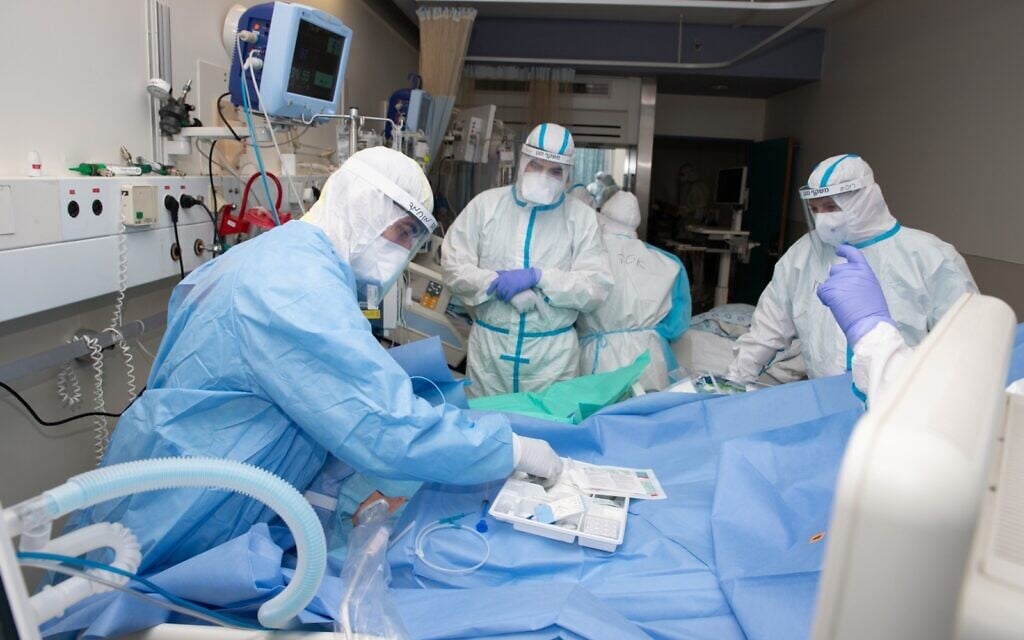 Medical staff treat a coronavirus patient at Shaare Zedek Medical Center in Jerusalem, July 2020. (Tal Cheres) Medical staff treat a coronavirus patient at Shaare Zedek Medical Center in Jerusalem, July 2020. (Tal Cheres)
