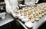 ILLUSTRATIVE — Cooks wrapping airline food in foil in a commercial kitchen. (iStock/Kondor83)