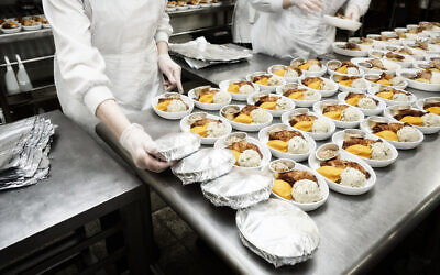 ILLUSTRATIVE — Cooks wrapping airline food in foil in a commercial kitchen. (iStock/Kondor83)