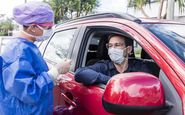 A doctor in a protective suit takes a nasal swab for a coronavirus test (iStock)