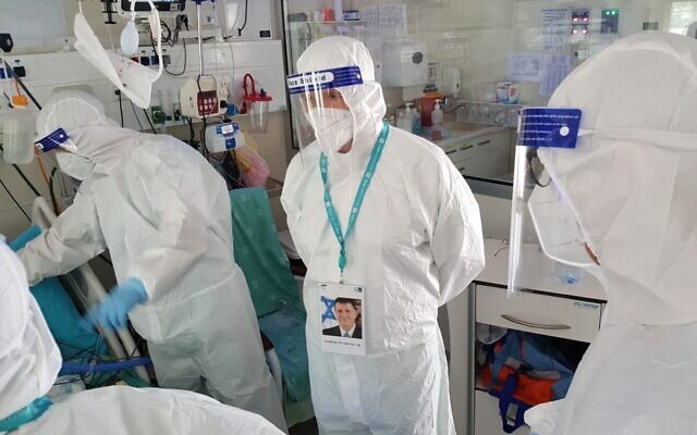 In this photo from the Health Ministry, Health Minister Yuli Edelstein (C) visits patients inside the coronavirus ward at Yitzhak Shamir Medical Center in Tzrifin on July 23, 2020. (Health Ministry) In this photo from the Health Ministry, Health Minister Yuli Edelstein (C) visits patients inside the coronavirus ward at Yitzhak Shamir Medical Center in Tzrifin on July 23, 2020. (Health Ministry)