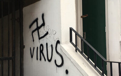Anti-Semitic graffiti scrawled in a UK stairwell in this undated photo juxtaposes Holocaust imagery with the current coronavirus crisis. (Community Security Trust)