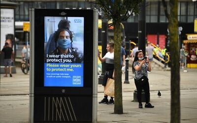 A large electronic billboard displays a message urging people to wear a face mask as a precuation against the transmission of the novel coronavirus, in Manchester, northwest England, on July 31, 2020 (Oli SCARFF / AFP)