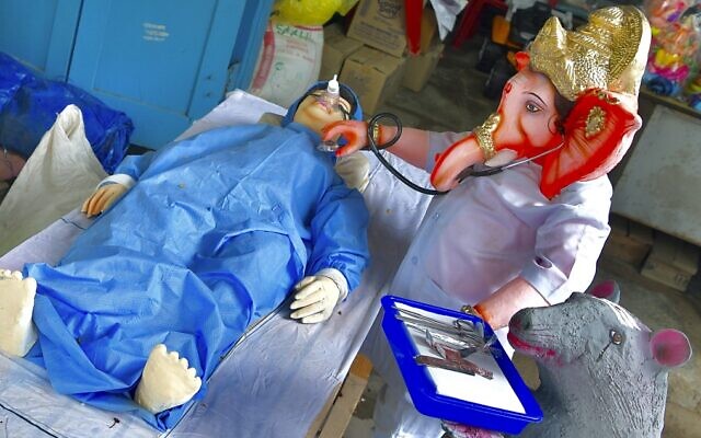 Plasters of Paris (PoP) idols depict the Hindu god Ganesh treating a COVID-19 patient, ahead of the Ganesh Chaturthi Festival, in Bangalore on August 1, 2020. (Manjunath Kiran/AFP) Plasters of Paris (PoP) idols depict the Hindu god Ganesh treating a COVID-19 patient, ahead of the Ganesh Chaturthi Festival, in Bangalore on August 1, 2020. (Manjunath Kiran/AFP)