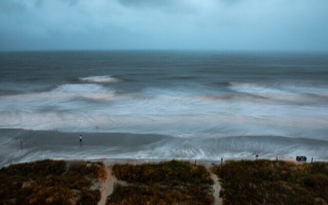 Large surf is swirled by the wind and captured by a long exposure, while a person stands on the shore as Hurricane Isaias approaches North Myrtle Beach, South Carolina on August 3, 2020.(Photo by Logan Cyrus / AFP) Large surf is swirled by the wind and captured by a long exposure, while a person stands on the shore as Hurricane Isaias approaches North Myrtle Beach, South Carolina on August 3, 2020.(Photo by Logan Cyrus / AFP)