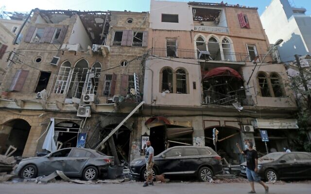 Pedestrians walks past damaged historic buildings on August 5, 2020 in Beirut's Gimmayzeh district which was heavily damaged by the previous day's powerful explosion that tore through Lebanon's capital, resulting from the ignition of a huge depot of ammonium nitrate at the city's main port. (Photo by STR / AFP) Pedestrians walks past damaged historic buildings on August 5, 2020 in Beirut's Gimmayzeh district which was heavily damaged by the previous day's powerful explosion that tore through Lebanon's capital, resulting from the ignition of a huge depot of ammonium nitrate at the city's main port. (Photo by STR / AFP)