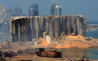 A picture taken on August 5, 2020 shows the damaged grain silo and a burnt boat at Beirut's harbour, one day after a powerful twin explosion tore through Lebanon's capital, resulting from the ignition of a huge depot of ammonium nitrate at the city's main port. (STR / AFP)
