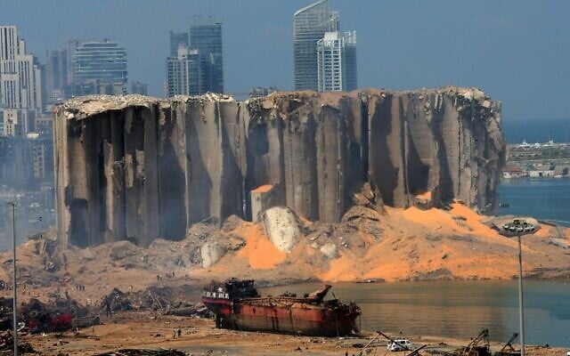 A picture taken on August 5, 2020 shows the damaged grain silo and a burnt boat at Beirut's harbour, one day after a powerful twin explosion tore through Lebanon's capital, resulting from the ignition of a huge depot of ammonium nitrate at the city's main port. (STR / AFP)