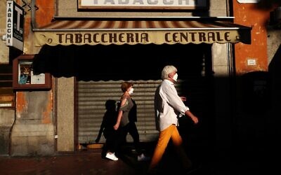 A man and a woman walk in a street of Ventimiglia on August 05, 2020. (Valery HACHE / AFP)