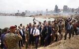 French President Emmanuel Macron (C), flanked on his right by French Foreign Minister Jean-Yves Le Drian, visits the devastated site of the explosion at the Beirut port on August 6, 2020. (Thibault Camus/Pool/AFP)