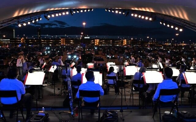 The Montreal Symphony Orchestra performs in a parking lot at Montreal-Pierre Elliott Trudeau International Airport on August 5, 2020, during a socially-distanced "drive-in" concert amid the COVID-19 outbreak. (Eric THOMAS/AFP) The Montreal Symphony Orchestra performs in a parking lot at Montreal-Pierre Elliott Trudeau International Airport on August 5, 2020, during a socially-distanced "drive-in" concert amid the COVID-19 outbreak. (Eric THOMAS/AFP)