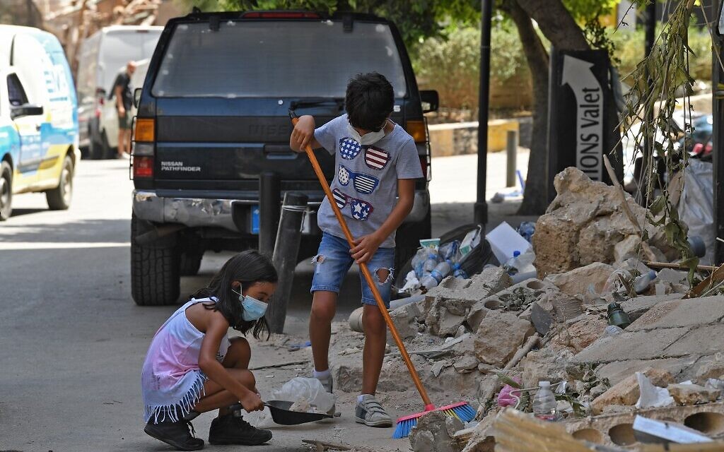Lebanese children clean debris in Beirut's Gemmayzeh neighborhood on August 8, 2020, four days after a monster explosion killed more than 150 people and disfigured the Lebanese capital. (AFP) Lebanese children clean debris in Beirut's Gemmayzeh neighborhood on August 8, 2020, four days after a monster explosion killed more than 150 people and disfigured the Lebanese capital. (AFP)