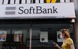 A woman walks past a SoftBank mobile store in Tokyo on August 11, 2020 (Kazuhiro NOGI / AFP)