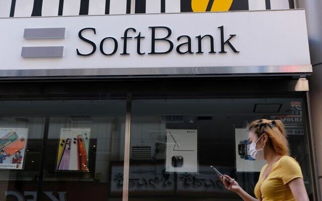 A woman walks past a SoftBank mobile store in Tokyo on August 11, 2020 (Kazuhiro NOGI / AFP)
