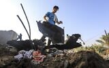 A youth moves debris on a rooftop following an Israeli air strike east of al-Bureij in the central Gaza Strip on August 15, 2020. (MAHMUD HAMS / AFP)