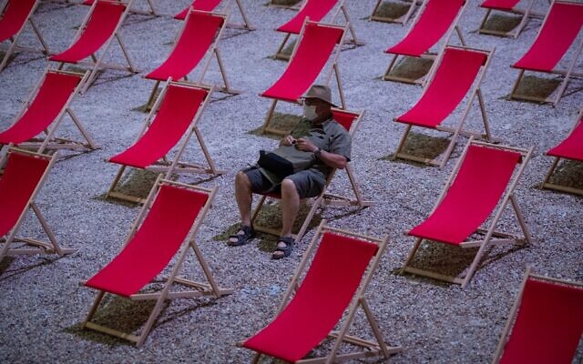 In this photo taken on July 18, 2020, a man waits for the start of a video projection in the "Cour d'Honneur du Palais des Papes" in Avignon, southern France. (CLEMENT MAHOUDEAU/AFP) In this photo taken on July 18, 2020, a man waits for the start of a video projection in the "Cour d'Honneur du Palais des Papes" in Avignon, southern France. (CLEMENT MAHOUDEAU/AFP)