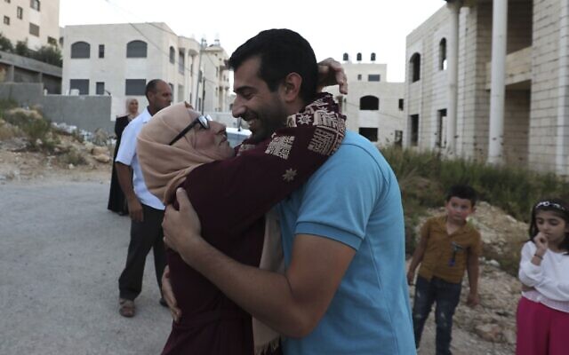 Relatives of Mahmoud Nawajaa, coordinator of the Boycott, Divestment and Sanctions (BDS) movement in the West Bank and Gaza, receive him after he was released from an Israeli prison, on August 17, 2020. (ABBAS MOMANI / AFP) Relatives of Mahmoud Nawajaa, coordinator of the Boycott, Divestment and Sanctions (BDS) movement in the West Bank and Gaza, receive him after he was released from an Israeli prison, on August 17, 2020. (ABBAS MOMANI / AFP)