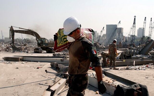 A French soldier carries a bag of rice as French forces aid the Lebanese army's work at the damaged site of the massive blast in Beirut's port area, in Beirut on August 31, 2020. (Gonzalo Fuentes/Pool/AFP) A French soldier carries a bag of rice as French forces aid the Lebanese army's work at the damaged site of the massive blast in Beirut's port area, in Beirut on August 31, 2020. (Gonzalo Fuentes/Pool/AFP)