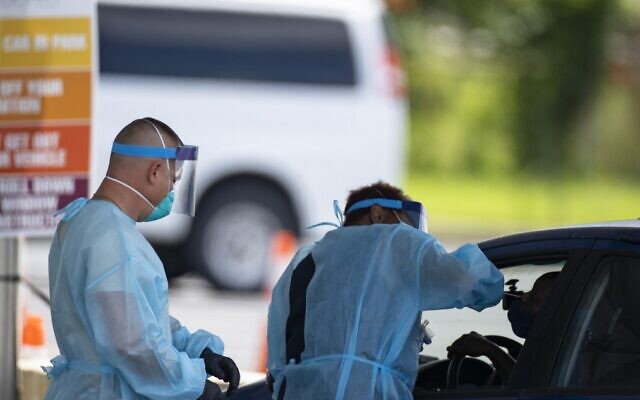 Healthcare workers takes a swab sample from a person in a car at a COVID-19 testing center outside Nissan Stadium on August 3, 2020, in Nashville, Tennessee. (Brett Carlsen/Getty Images/AFP) Healthcare workers takes a swab sample from a person in a car at a COVID-19 testing center outside Nissan Stadium on August 3, 2020, in Nashville, Tennessee. (Brett Carlsen/Getty Images/AFP)