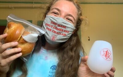 Cornell student Aliza Saunders shows off the supplies she got to celebrate Shabbat on her own. (Courtesy of Cornell Hillel/ via JTA)