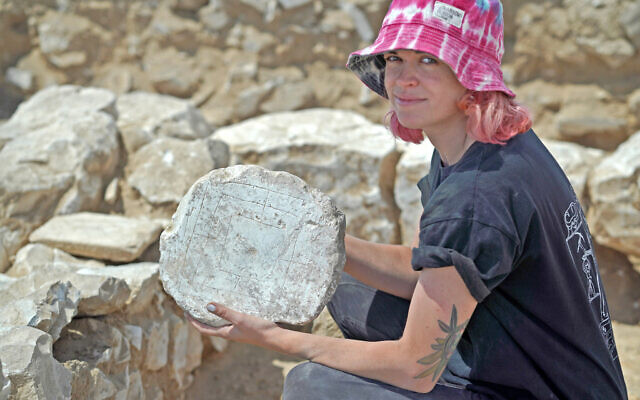 High school student Jenny Vasiutin holding the 'Windmill' game board, found during IAA excavations in Rahat, a Beduin city in the Negev Desert. (Emil Aladjem/Israel Antiquities Authority) High school student Jenny Vasiutin holding the 'Windmill' game board, found during IAA excavations in Rahat, a Beduin city in the Negev Desert. (Emil Aladjem/Israel Antiquities Authority)