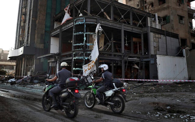 Police officers pass a damaged building near the scene of an explosion that hit the seaport of Beirut, Lebanon, August 5, 2020. (Bilal Hussein/AP) Police officers pass a damaged building near the scene of an explosion that hit the seaport of Beirut, Lebanon, August 5, 2020. (Bilal Hussein/AP)