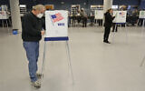 This Tuesday, April 28, 2020 file photo shows Jerome Fedor, left, voting using social distancing at the Cuyahoga County Board of Elections, in Cleveland, Ohio (AP Photo/Tony Dejak, File)