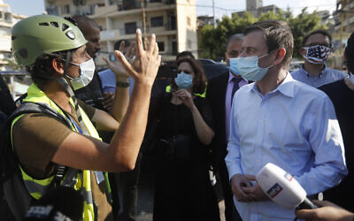 US Undersecretary of State for Political Affairs David Hale, right, listens to an NGO volunteer during his visit to a main gathering point for volunteers, near the site of the explosion that hit the seaport of Beirut, Lebanon, August 13, 2020. (AP Photo/Hussein Malla, Pool)