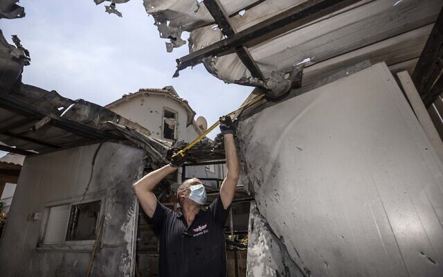 An Israeli police officer inspects the damage to a home after it was hit by a rocket fired by Palestinian militants from the Gaza Strip, in Sderot on August 16, 2020. (AP Photo/Tsafrir Abayov) An Israeli police officer inspects the damage to a home after it was hit by a rocket fired by Palestinian militants from the Gaza Strip, in Sderot on August 16, 2020. (AP Photo/Tsafrir Abayov)