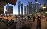 Two men play backgammon while smoking a shisha water pipe at a restaurant overlooking the canal and the Dubai Marina neighborhood in Dubai, United Arab Emirates, on May 1, 2015. (AP Photo/Kamran Jebreili, File)