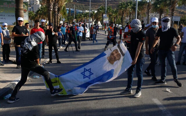 Palestinians with a banner showing Abu Dhabi Crown Prince Mohammed bin Zayed al-Nahyan wearing an Israeli flag, during a rally against the United Arab Emirates' normalization deal with Israel, in the West Bank village of Turmusaya near Ramallah, Aug. 19, 2020. (AP Photo/Majdi Mohammed) Palestinians with a banner showing Abu Dhabi Crown Prince Mohammed bin Zayed al-Nahyan wearing an Israeli flag, during a rally against the United Arab Emirates' normalization deal with Israel, in the West Bank village of Turmusaya near Ramallah, Aug. 19, 2020. (AP Photo/Majdi Mohammed)