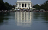 The Lincoln Memorial is reflected in the water as people gather to attend the March on Washington, Friday Aug. 28, 2020, in Washington, on the 57th anniversary of the Rev. Martin Luther King Jr.'s 'I Have A Dream' speech. (AP Photo/Carolyn Kaster)