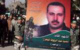 Palestinians carry a picture of Mahmoud al-Mabhouh, as others carry his coffin, left, during his funeral procession at Yarmouk, near Damascus, Syria, January 29, 2010. (AP Photo/Bassem Tellawi/File)