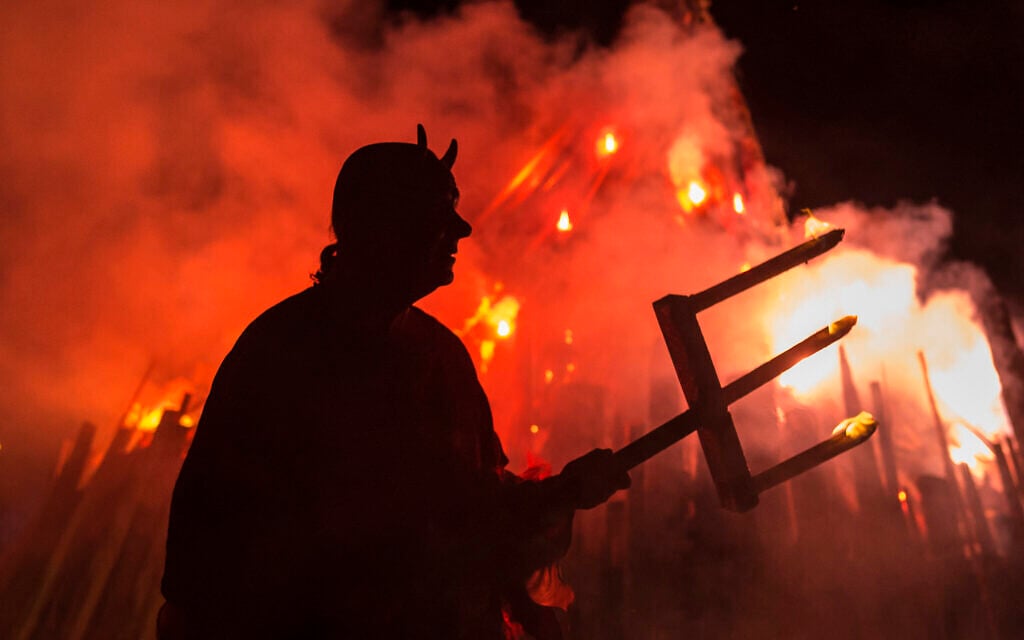 Illustrative: A man dressed as a devil performs in front of a giant fire during the Walpurgis night in Erfurt, central Germany, Sunday, April 30, 2017. (AP Photo/Jens Meyer) Illustrative: A man dressed as a devil performs in front of a giant fire during the Walpurgis night in Erfurt, central Germany, Sunday, April 30, 2017. (AP Photo/Jens Meyer)