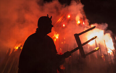 Illustrative: A man dressed as a devil performs in front of a giant fire during the Walpurgis night in Erfurt, central Germany, Sunday, April 30, 2017. (AP Photo/Jens Meyer)