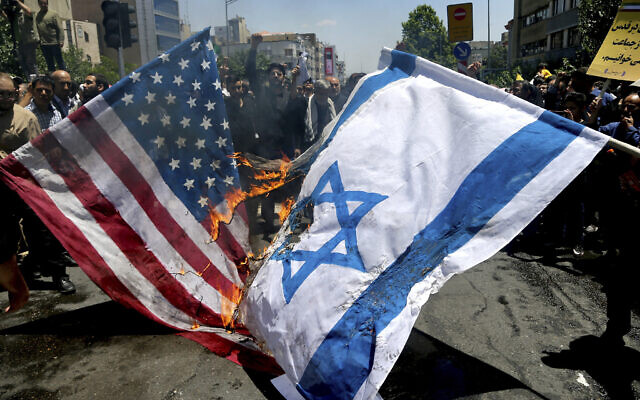 Iranian protesters burn Israeli and US flags on June 8, 2018. (AP/Ebrahim Noroozi) Iranian protesters burn Israeli and US flags on June 8, 2018. (AP/Ebrahim Noroozi)