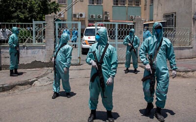 Palestinian Hamas police officers wear protective suits as they take part in a simulation of possible coronavirus infections in Gaza City, Saturday, July 18, 2020. (AP/Khalil Hamra)