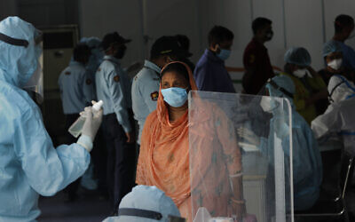 Indian health volunteers register people participating in the India-Israel Non-Invasive Raid COVID-19 test study camp, at a government hospital in New Delhi, India, Friday, July 31, 2020. (AP/Manish Swarup)