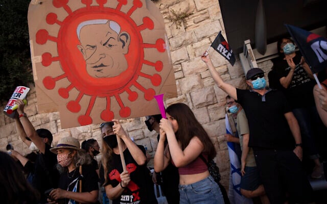 A protester holds a sign depicting Prime Minister Benjamin Netanyahu during a protest a against him outside the PM's residence in Jerusalem, on July 31, 2020. (AP Photo/Oded Balilty) A protester holds a sign depicting Prime Minister Benjamin Netanyahu during a protest a against him outside the PM's residence in Jerusalem, on July 31, 2020. (AP Photo/Oded Balilty)