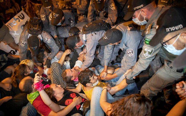 Police clear off protesters who blocked a main road during a protest against Israel's Prime Minister Benjamin Netanyahu outside his residence in Jerusalem early Sunday, Aug 2, 2020. (AP/Oded Balilty) Police clear off protesters who blocked a main road during a protest against Israel's Prime Minister Benjamin Netanyahu outside his residence in Jerusalem early Sunday, Aug 2, 2020. (AP/Oded Balilty)