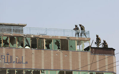 Afghan security personnel take position on the top of a building where insurgents were hiding, in the city of Jalalabad, east of Kabul, Afghanistan, Monday, Aug. 3, 2020. An Islamic State group attack on a prison in eastern Afghanistan holding hundreds of its members raged on Monday after killing people in fighting overnight, a local official said. (AP Photo/Rahmat Gul)