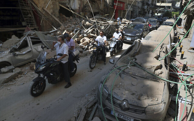People drive past buildings and cars that were damaged in the previous day's massive explosion in the seaport of Beirut, Lebanon, August 5, 2020. (AP Photo/Bilal Hussein) People drive past buildings and cars that were damaged in the previous day's massive explosion in the seaport of Beirut, Lebanon, August 5, 2020. (AP Photo/Bilal Hussein)