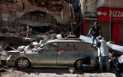 People inspect their car, damaged in the previous day's massive explosion in the seaport of Beirut, Lebanon, August 5, 2020. (AP/Bilal Hussein)