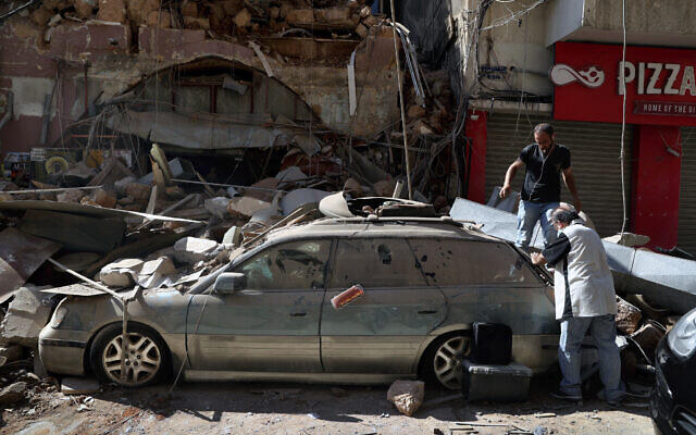 People inspect their car, damaged in the previous day's massive explosion in the seaport of Beirut, Lebanon, August 5, 2020. (AP/Bilal Hussein) People inspect their car, damaged in the previous day's massive explosion in the seaport of Beirut, Lebanon, August 5, 2020. (AP/Bilal Hussein)