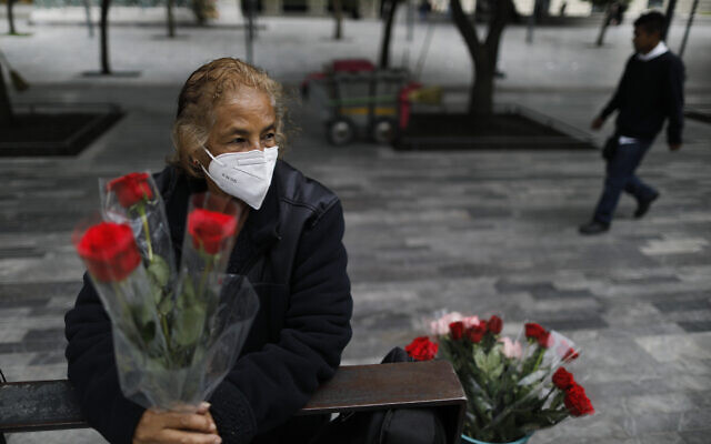 Wearing a mask to curb the spread of the new coronavirus, Martha Gonzalez Reyes, 76, sells roses outside Metro Hidalgo in central Mexico City, Monday, Aug. 10, 2020. After four months staying at home, Gonzalez returned to selling on August 1, but she says business hasn't fully rebounded. "People have less money to spend she says, and they don't want to go out and get infected."(AP Photo/Rebecca Blackwell) Wearing a mask to curb the spread of the new coronavirus, Martha Gonzalez Reyes, 76, sells roses outside Metro Hidalgo in central Mexico City, Monday, Aug. 10, 2020. After four months staying at home, Gonzalez returned to selling on August 1, but she says business hasn't fully rebounded. "People have less money to spend she says, and they don't want to go out and get infected."(AP Photo/Rebecca Blackwell)