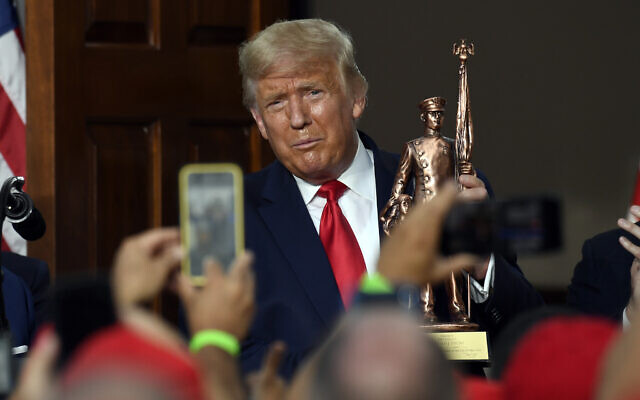 US President Donald Trump holds a statue presented to him as he speaks during an event Trump National Golf Club, Aug. 14, 2020, in Bedminster, N.J., with members of the City of New York Police Department Benevolent Association. (AP Photo/Susan Walsh) US President Donald Trump holds a statue presented to him as he speaks during an event Trump National Golf Club, Aug. 14, 2020, in Bedminster, N.J., with members of the City of New York Police Department Benevolent Association. (AP Photo/Susan Walsh)
