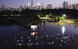 People watch a movie from small boats at 'sail-in' floating cinema at HaYarkon Park's boating lake in Tel Aviv, Israel, Aug. 20, 2020 (AP Photo/Oded Balilty)